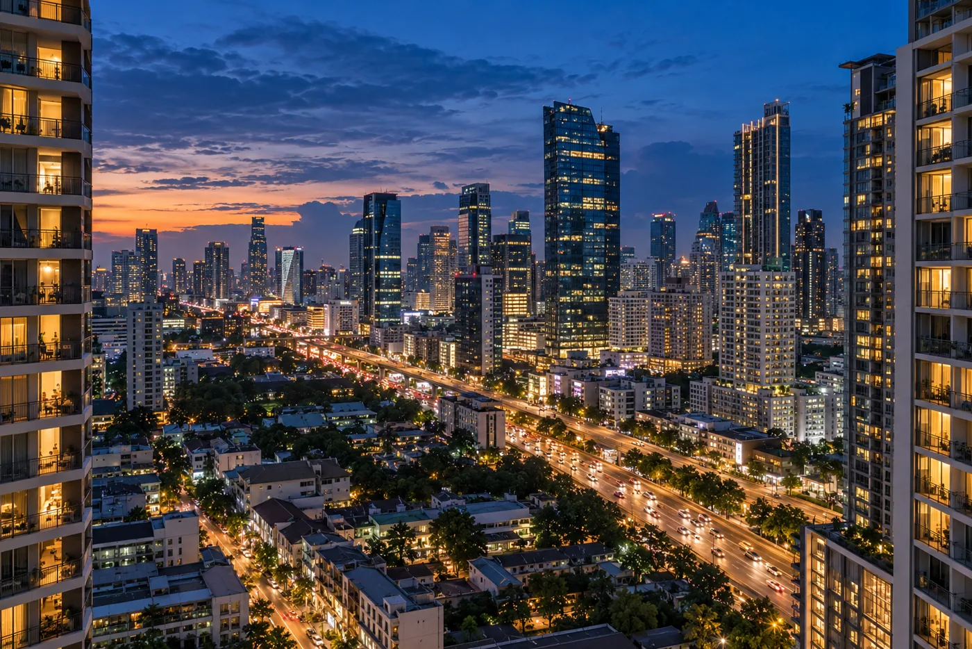 Evening view across the Rama 9 district of Bangkok from a high residential floor, with lit condominium towers, balconies and the broad road below