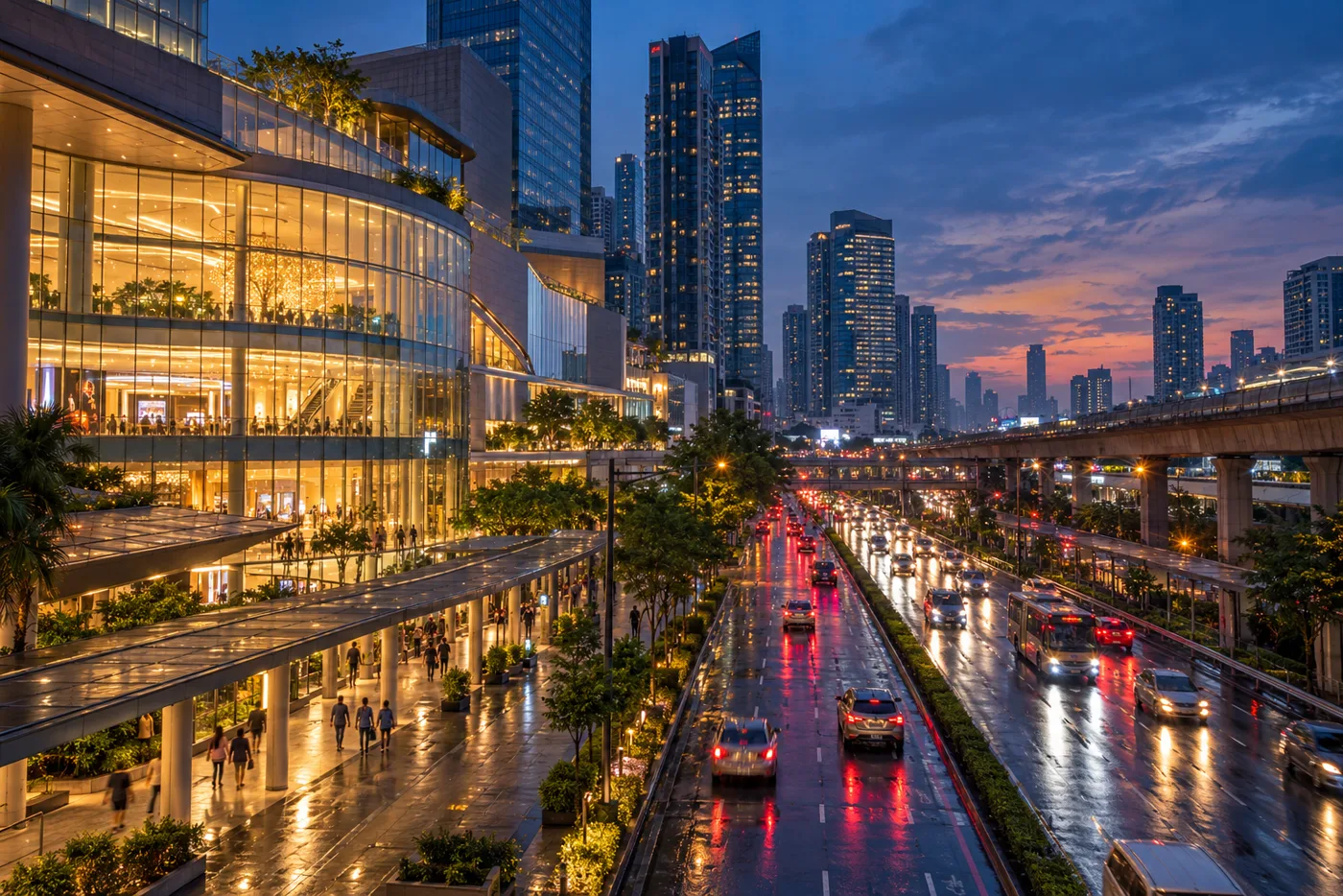 A busy road junction in Bangkok's Rama 9 district at dusk, with a large shopping mall, glass office and condominium towers, and pedestrians walking along a covered pavement towards the mall entrance.